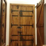 باب خشبي مزدوج مزين بتدريب شرائح حديدية سوداء كلاسيكية (Rustic Double Door with Heavy Iron Straps)